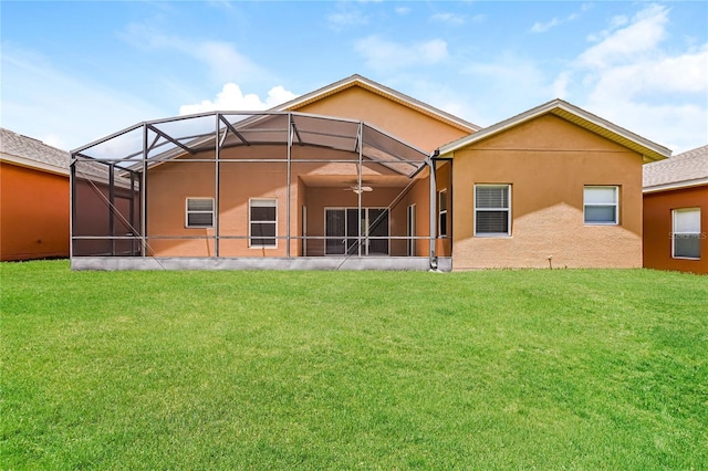 rear view of property with a lawn and glass enclosure