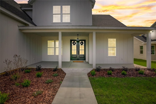 exterior entry at dusk with covered porch and a yard