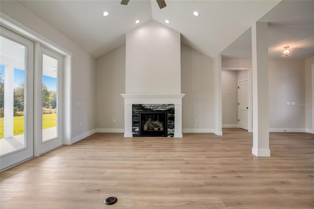 unfurnished living room featuring light hardwood / wood-style floors, a fireplace, ceiling fan, and lofted ceiling