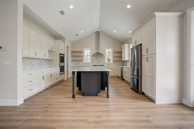 kitchen featuring a kitchen island, stainless steel appliances, tasteful backsplash, a kitchen bar, and white cabinetry