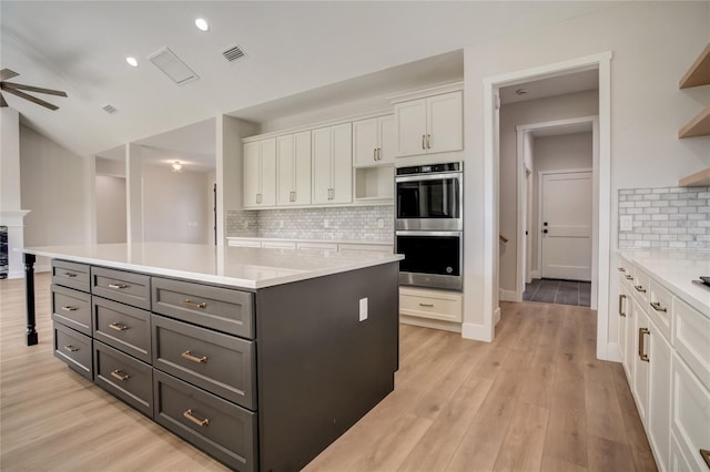 kitchen featuring white cabinets, backsplash, light hardwood / wood-style floors, and ceiling fan