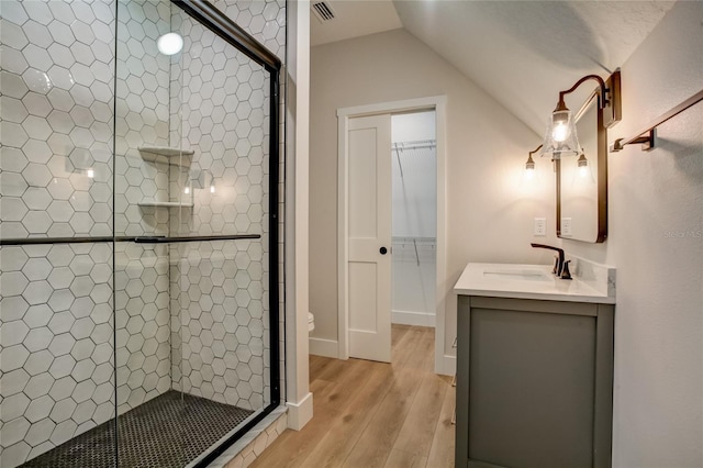 bathroom featuring toilet, an enclosed shower, lofted ceiling, vanity, and hardwood / wood-style flooring