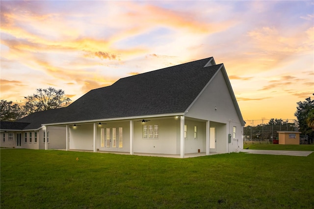 property exterior at dusk featuring a yard