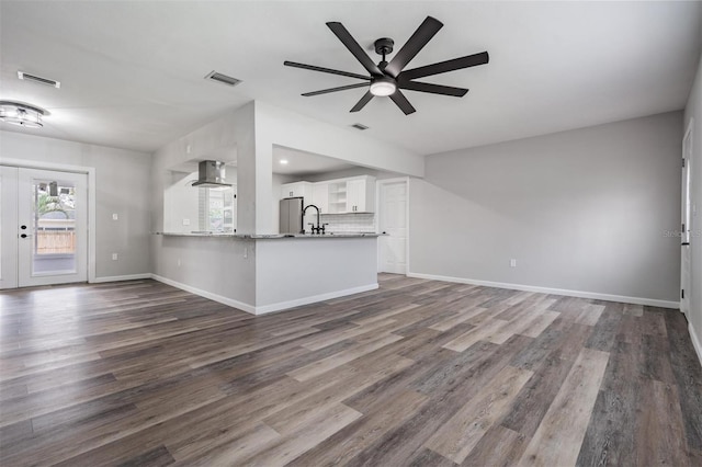 unfurnished living room featuring ceiling fan and dark wood-type flooring