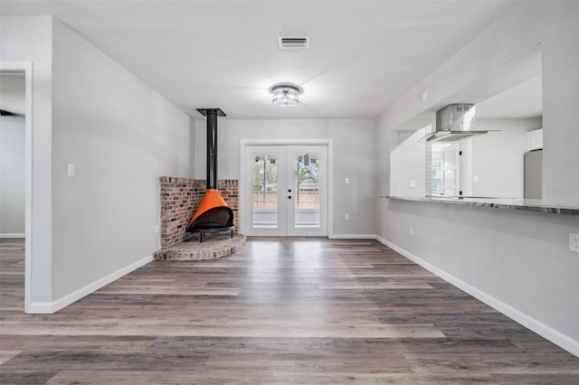 interior space featuring a wood stove, french doors, and dark hardwood / wood-style flooring