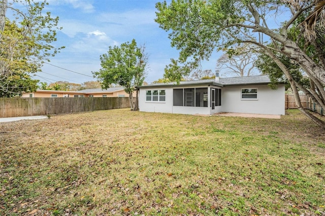 back of property featuring a sunroom and a yard