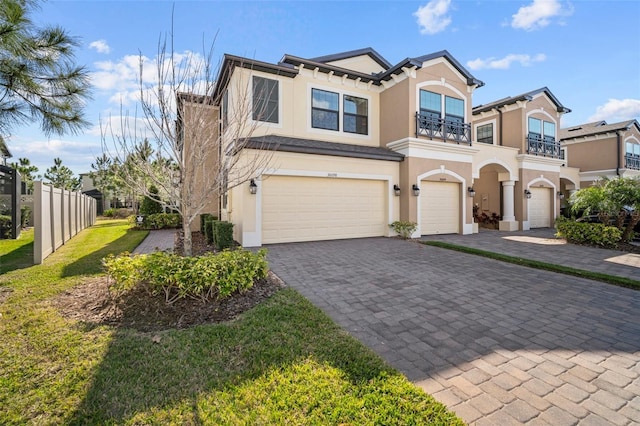 view of front of house featuring a front lawn, a balcony, and a garage