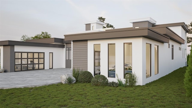 back of house featuring a lawn and a patio area