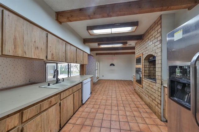 kitchen with sink, hanging light fixtures, appliances with stainless steel finishes, light tile flooring, and beam ceiling