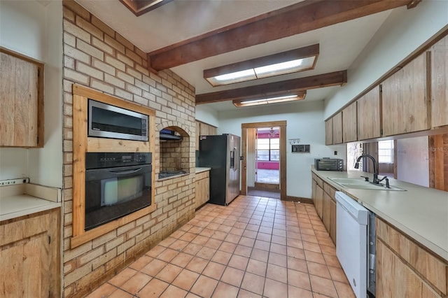 kitchen featuring appliances with stainless steel finishes, sink, beamed ceiling, and light tile floors