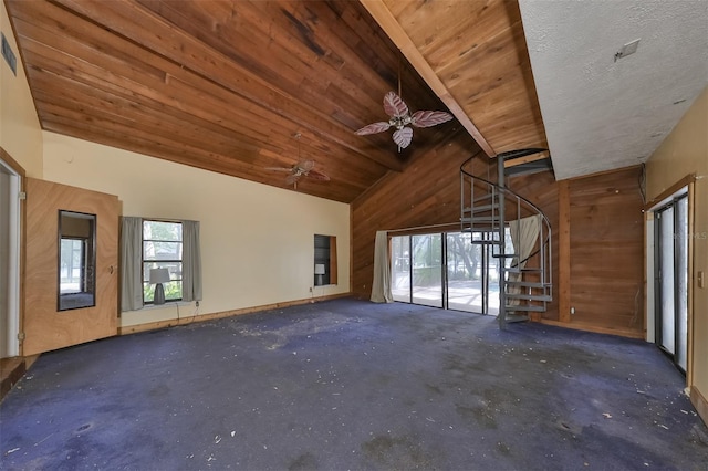 unfurnished room with wood walls, wooden ceiling, ceiling fan, a textured ceiling, and lofted ceiling