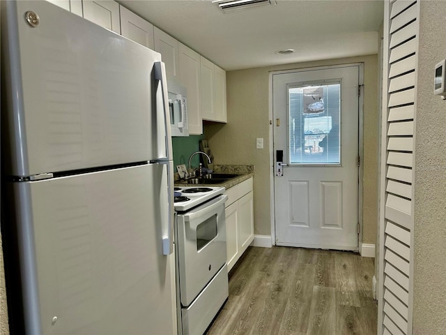 kitchen featuring white appliances, white cabinetry, sink, and light hardwood / wood-style flooring