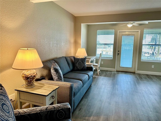 living room with lofted ceiling, plenty of natural light, ceiling fan, and dark wood-type flooring