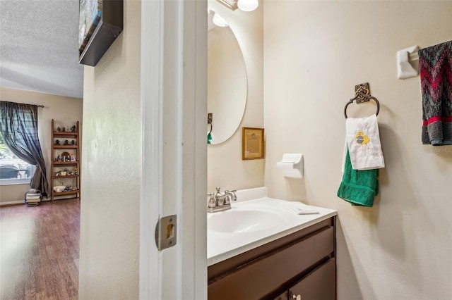 bathroom with hardwood / wood-style floors, a textured ceiling, and large vanity