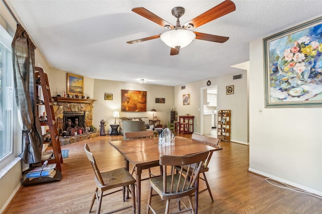 dining room with a textured ceiling, ceiling fan, and hardwood / wood-style flooring