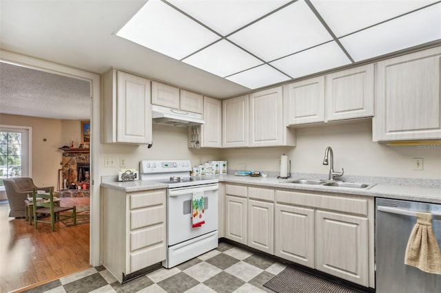 kitchen with sink, light wood-type flooring, white range with electric cooktop, stainless steel dishwasher, and a stone fireplace