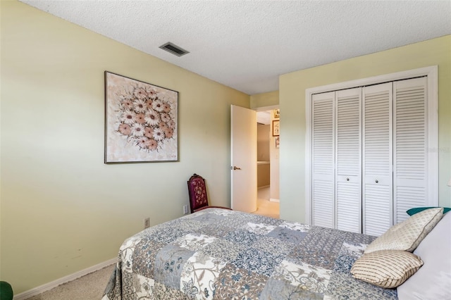 carpeted bedroom featuring a textured ceiling and a closet