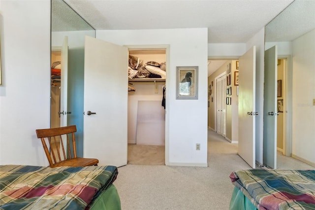 carpeted bedroom featuring a spacious closet, a textured ceiling, and a closet