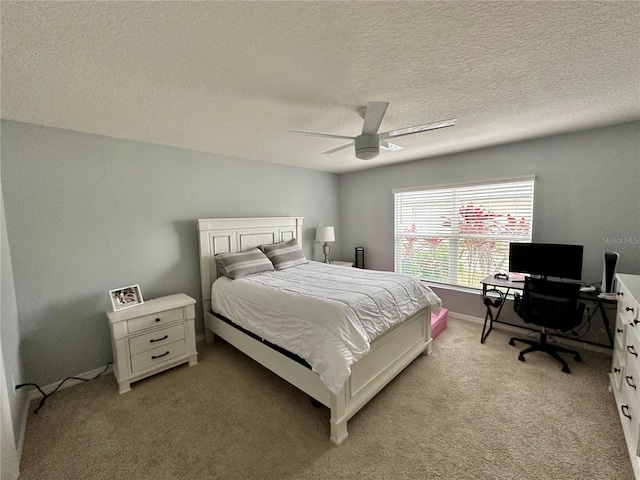 bedroom with a textured ceiling, light colored carpet, and ceiling fan