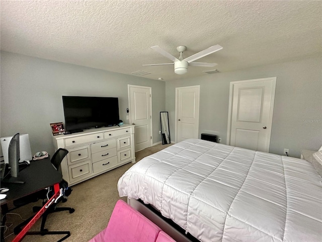 carpeted bedroom featuring visible vents, a textured ceiling, and a ceiling fan