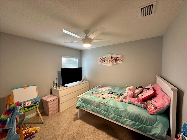 carpeted bedroom with a ceiling fan, visible vents, and a textured ceiling