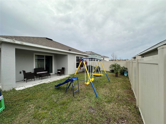 view of yard with a patio, a fenced backyard, and a playground