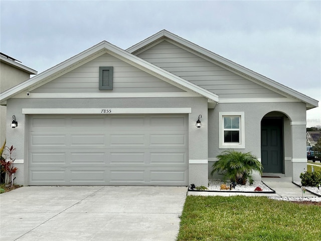 ranch-style home featuring stucco siding, driveway, and an attached garage