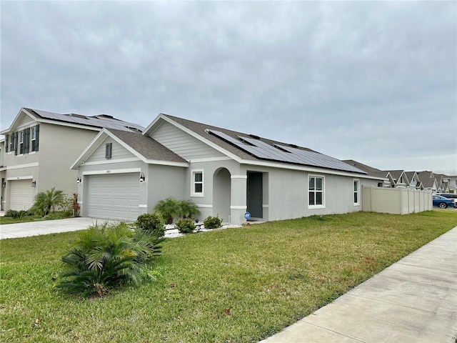 view of front of house featuring stucco siding, a front lawn, roof mounted solar panels, concrete driveway, and a garage