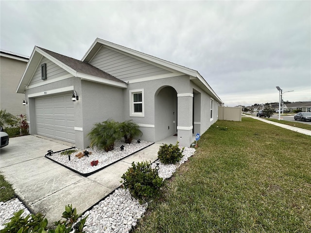 ranch-style home with a garage and a front lawn