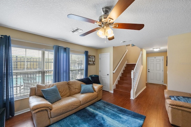 living room featuring plenty of natural light, ceiling fan, a textured ceiling, and dark hardwood / wood-style flooring