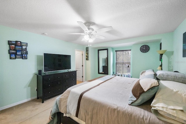 bedroom featuring light carpet, ceiling fan, and a textured ceiling