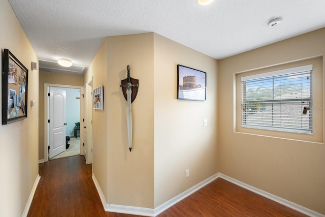 hall with a textured ceiling and dark hardwood / wood-style flooring