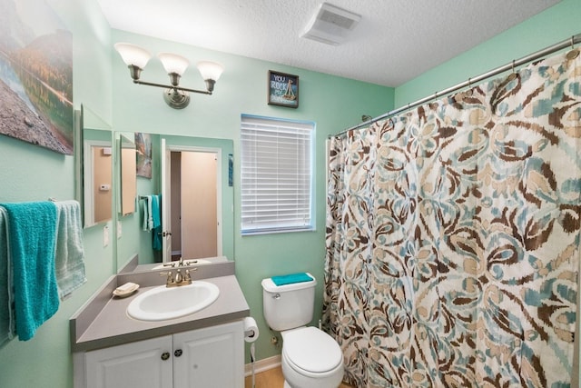 bathroom with vanity, a textured ceiling, and toilet