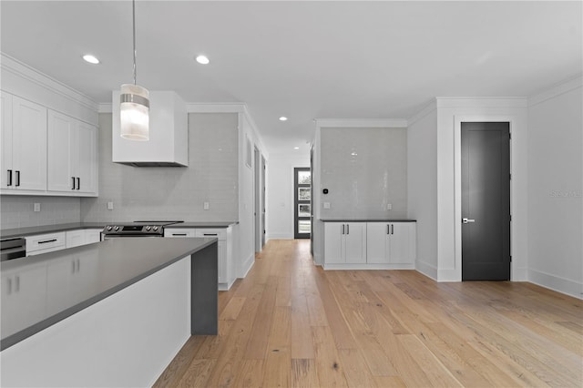 kitchen with light wood-type flooring, tasteful backsplash, decorative light fixtures, white cabinets, and stainless steel electric range oven