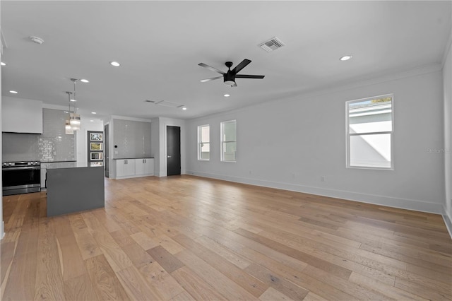 unfurnished living room featuring ceiling fan, light hardwood / wood-style floors, and ornamental molding