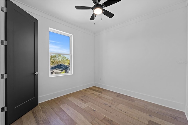 spare room with light wood-type flooring, ceiling fan, and crown molding