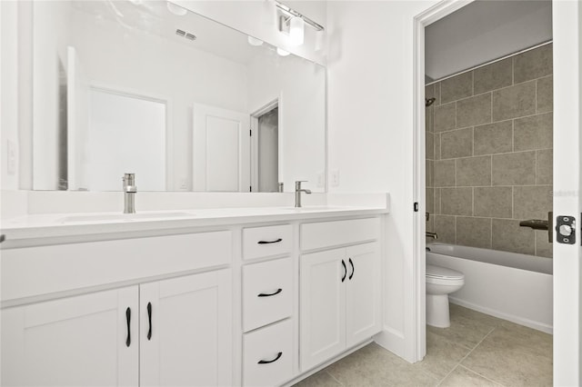 full bathroom featuring toilet, tiled shower / bath, vanity, and tile patterned flooring