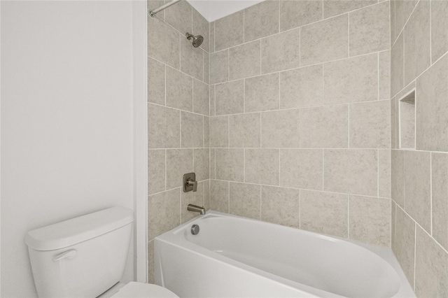 bathroom with tiled shower / bath combo and toilet