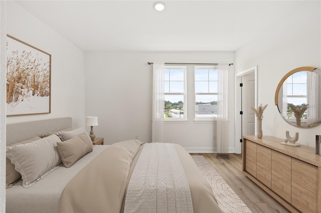 bedroom featuring multiple windows and light wood-type flooring