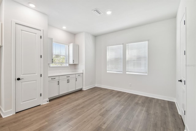 interior space with light hardwood / wood-style floors and white cabinets