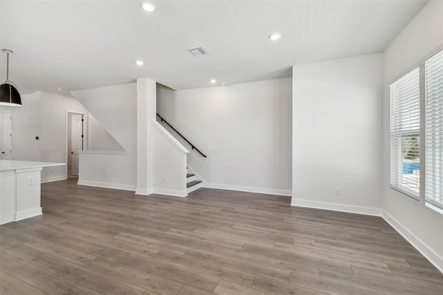 unfurnished living room with wood-type flooring and plenty of natural light