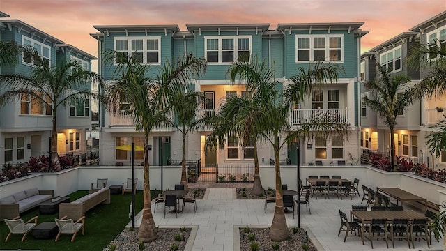 back of house at dusk with an outdoor hangout area and a patio