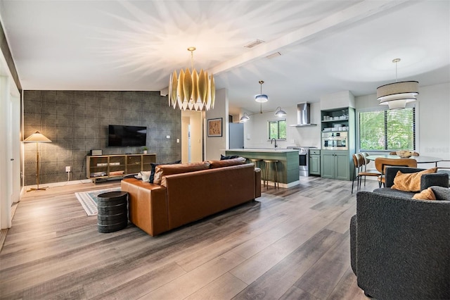 living room featuring tile walls, lofted ceiling with beams, and light hardwood / wood-style floors