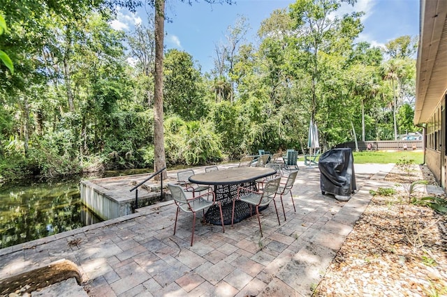 view of patio featuring area for grilling and a water view