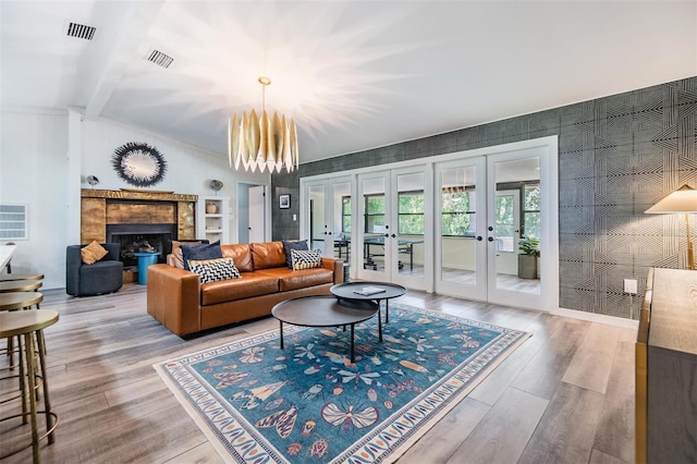 living room featuring hardwood / wood-style floors, french doors, vaulted ceiling with beams, and an inviting chandelier