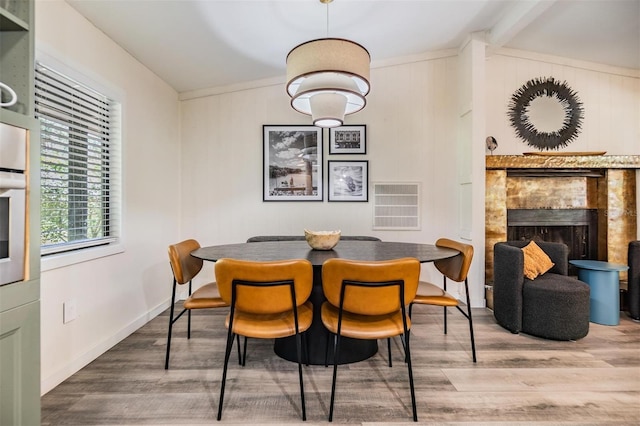 dining room featuring vaulted ceiling with beams and hardwood / wood-style floors