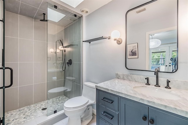 bathroom with toilet, a shower with shower door, vanity, and tile patterned flooring