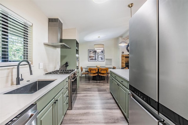 8952 W White Dogwood Dr, Homosassa, FL 34448 - kitchen with green cabinetry, appliances with stainless steel finishes, wall chimney range hood, a sink, and light countertops