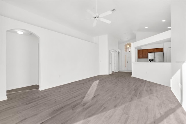 unfurnished living room with high vaulted ceiling, ceiling fan, and hardwood / wood-style flooring