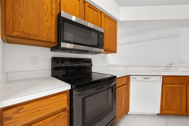 kitchen featuring white dishwasher, electric stove, light tile flooring, and sink